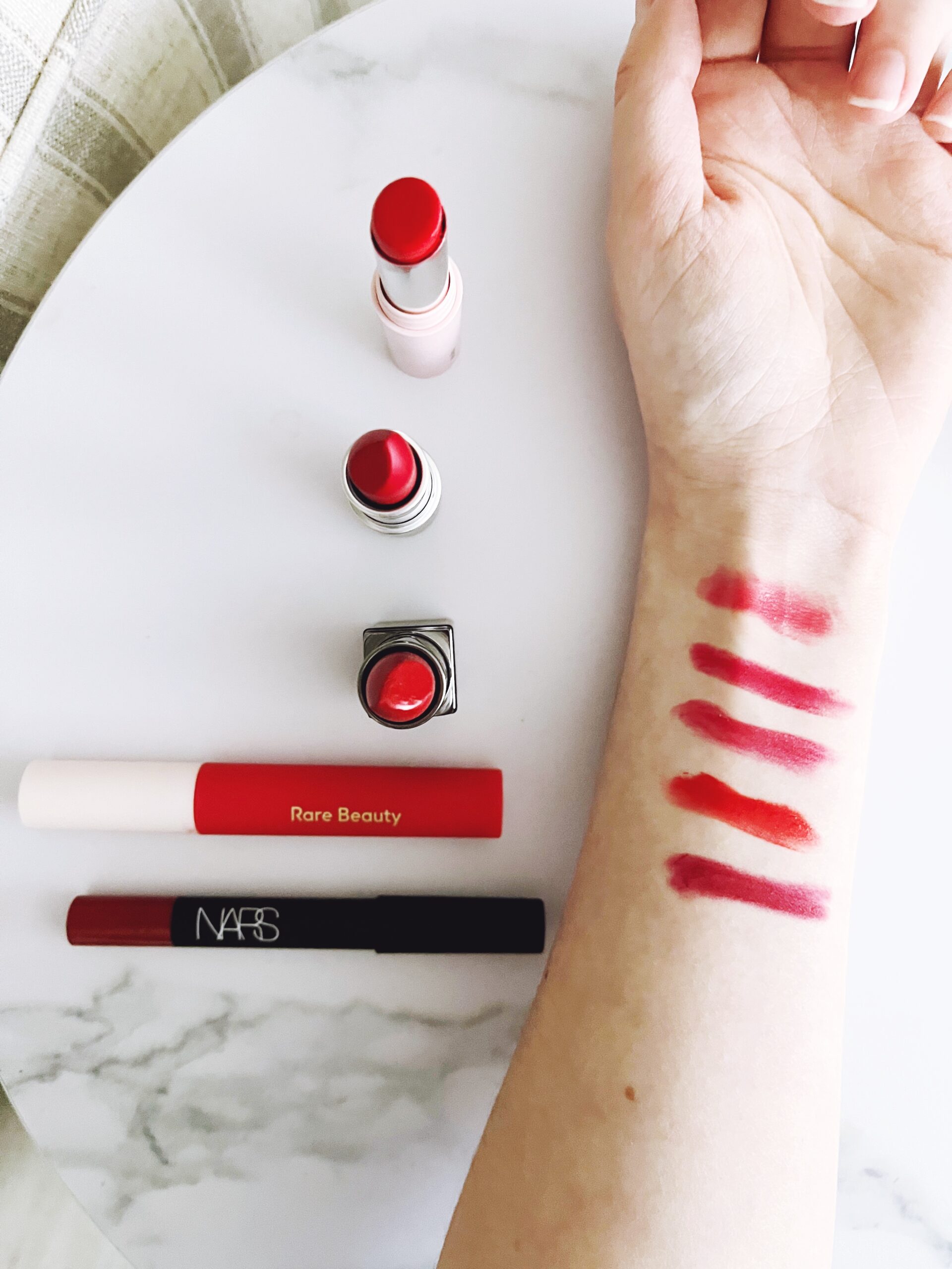 Swatches of red lipsticks of fair, cool-toned skin